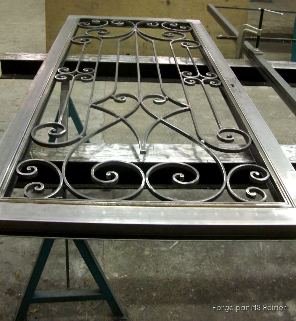 Porte d'entrée en fer forgé en cours de fabrication dans l'atelier de MS Poirier