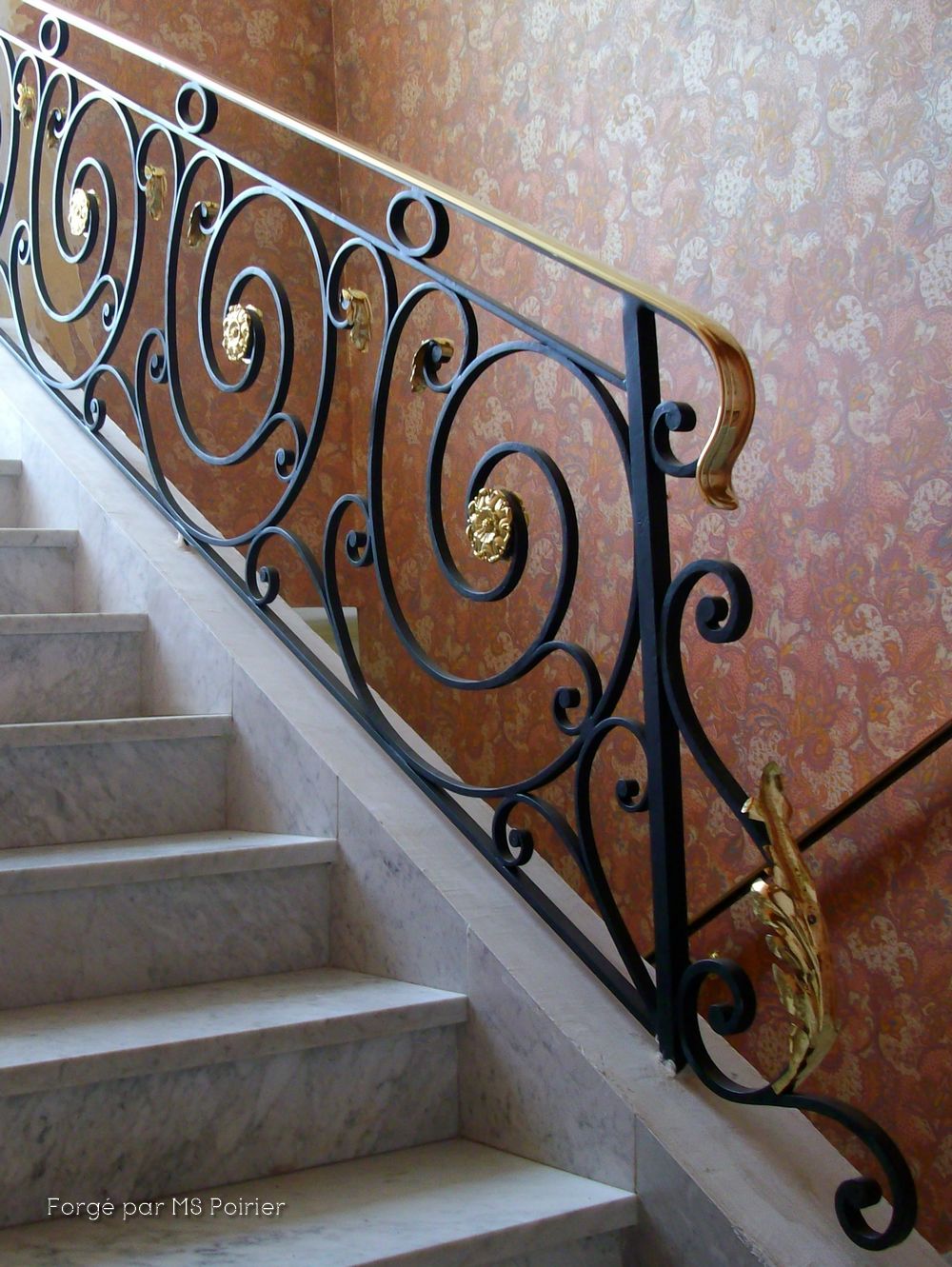 Rampe en fer forgé style Louis XVI sur un petit escalier. Belle feuille d'acanthe en laiton poli au départ